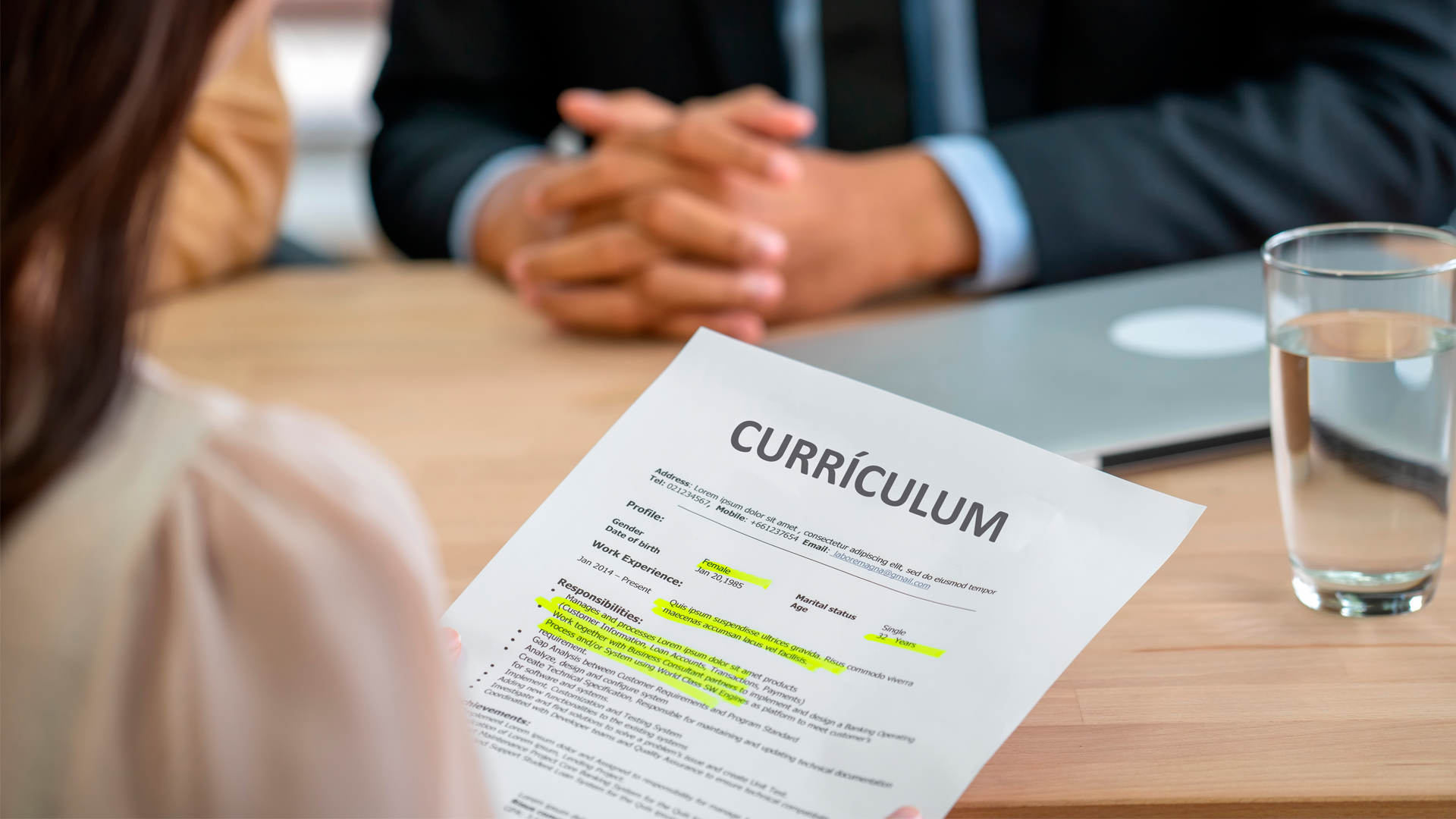 Mujer sostiene Currículum Vitae durante entrevista de trabajo. ECE. Trimestre MAM 2023.